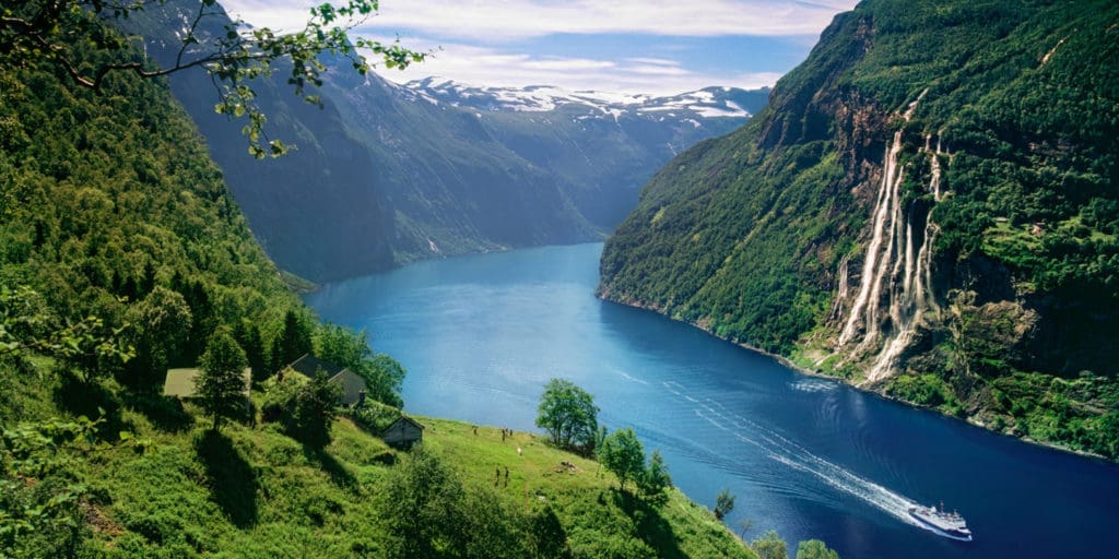 UNESCO-listede Geirangerfjord med den ikoniske Skageflå-fossen som fosser inn i fjorden, omgitt av dramatiske fjell